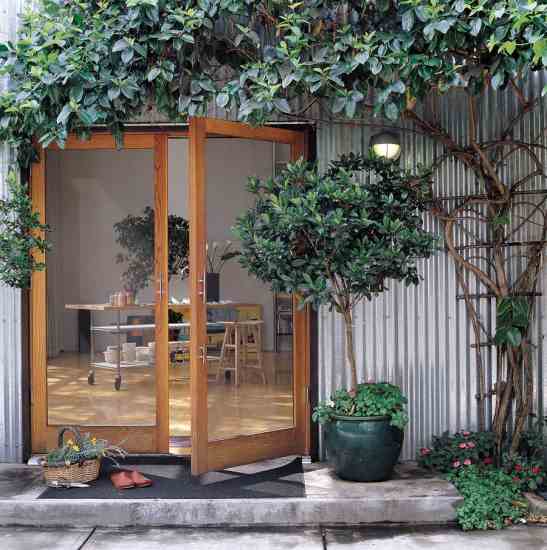 Jana and Claudio have made use of nearly every inch of their urban lot to grow food and fresh flowers, creating a lush oasis in the city. Gardenia trees and a honeysuckle vine perfume the entryway; lavender and old-fashioned roses provide romance. Rosemary is essential for the Italian dishes Jana makes, and a productive vegetable garden behind the home keeps the kitchen well-stocked. A slow-growing hybrid dwarf grass (Bonsai) lawn and drought-resistant landscaping help foster an atmosphere of calm.